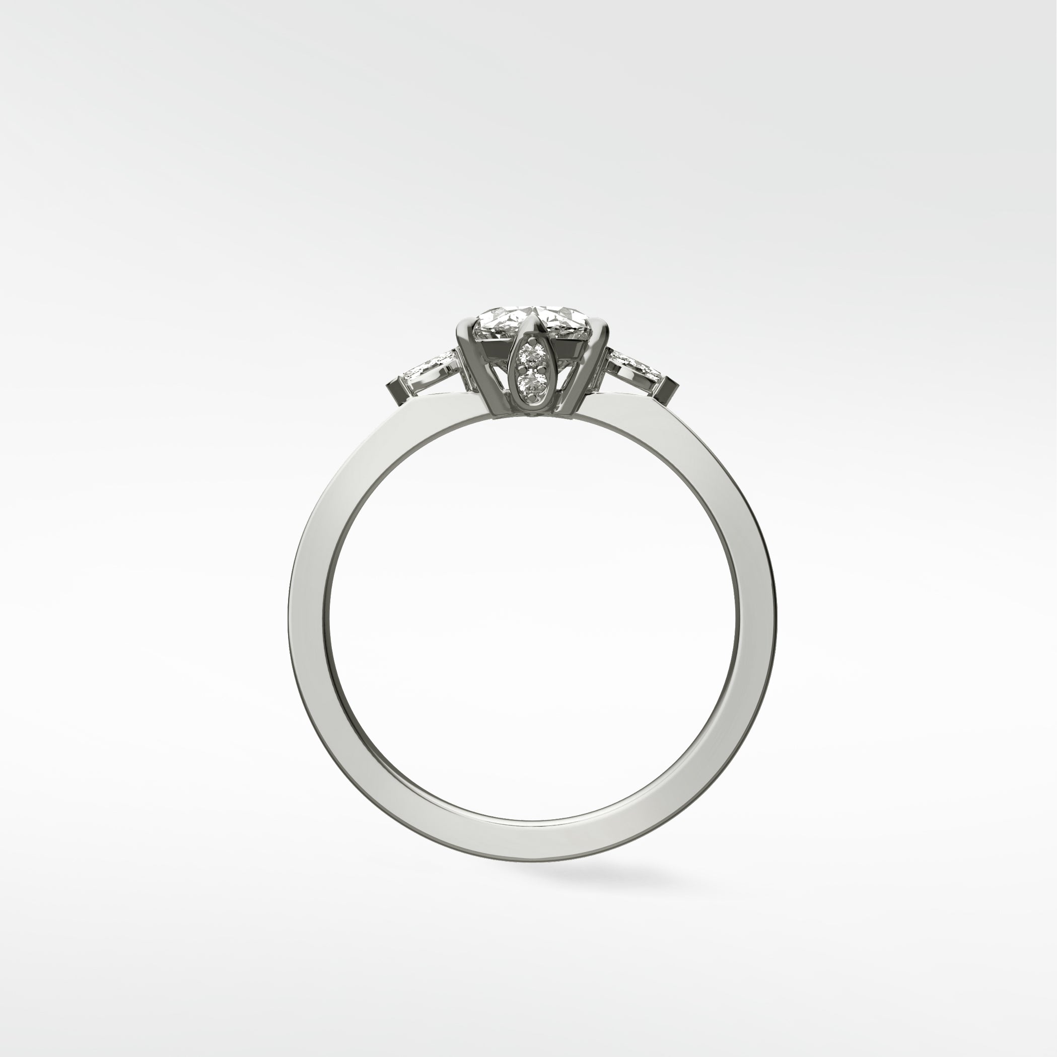 Side view of the Fern Engagement Ring with an oval diamond and tapered baguette side stones on a sleek white gold band.