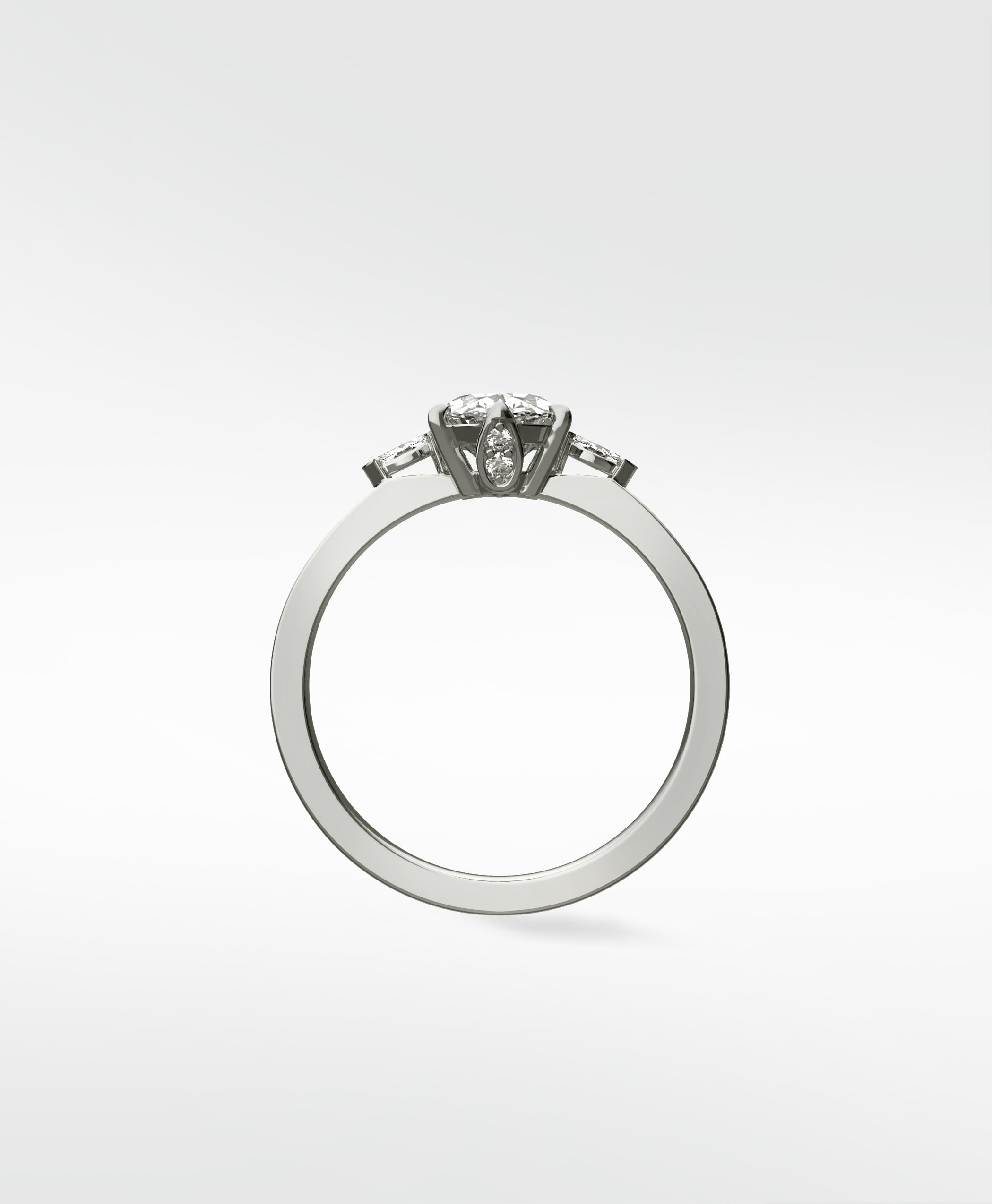 Side view of the Fern Engagement Ring with an oval diamond and tapered baguette side stones on a sleek white gold band.