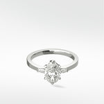 The Fern Engagement Ring with an oval diamond center stone and marquise accents on a platinum band.
